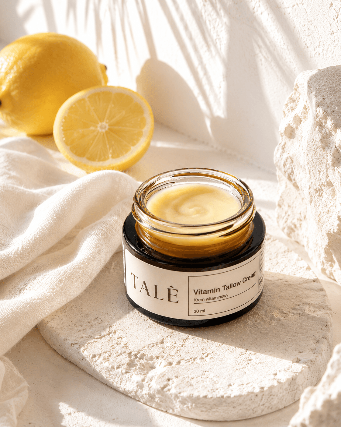 Słoik kremu Vitamin Tallow Cream obok świeżych cytryn